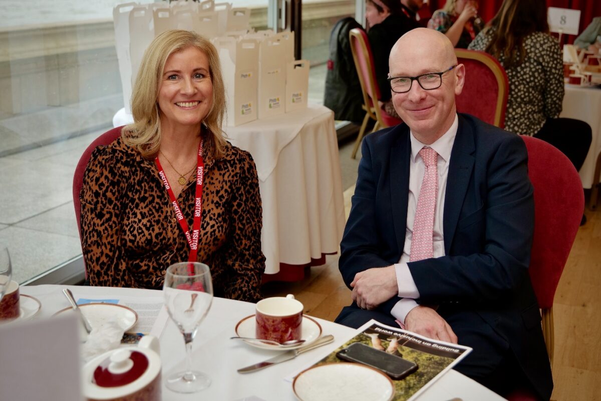 Patrick Hurley, MP for Southport, and Phab’s Rebecca Hargreaves, posing together whilst sat a table for afternoon tea; during Phab’s 2025 Awards Celebration at the House of Lords.
